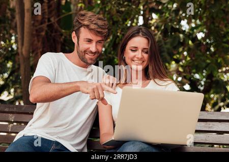 Freunde Sitzbank mit Laptop Stockfoto
