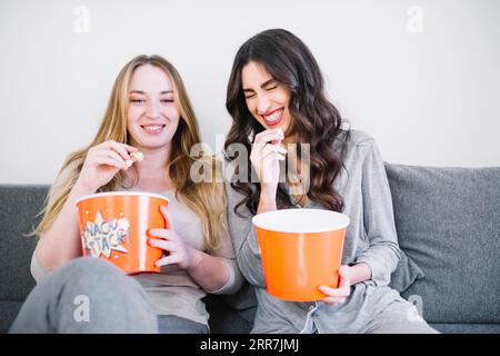 Lachende Frauen mit Popcorn Stockfoto