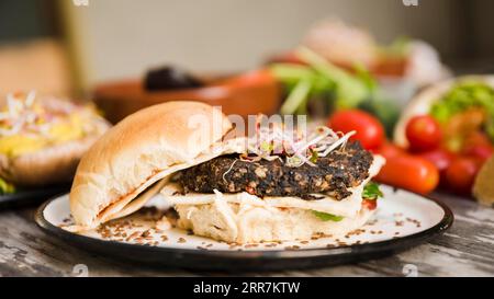 Veggie-Quinoa-Burger mit Sprossen, Leinsamen, weißer Teller Stockfoto