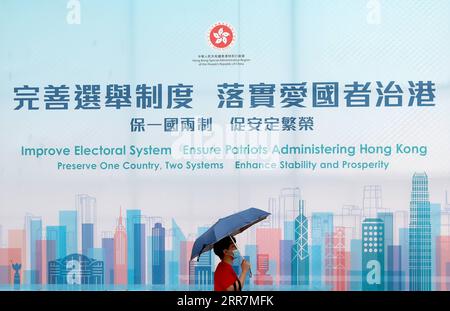 210331 -- HONGKONG, 31. März 2021 -- Ein Fußgänger geht an einem Poster über die Verbesserung des Wahlsystems und die Sicherstellung der Patrioten, die Hongkong im südchinesischen Hongkong verwalten, vorbei, 31. März 2021. Xinhua Schlagzeilen: Hongkongs neues Wahlsystem: Was kommt als nächstes WuxXiaochu PUBLICATIONxNOTxINxCHN Stockfoto