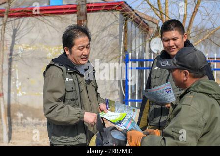 210331 -- BAICHENG, 31. März 2021 -- Mitglieder des Zhenlai Vogelschutzteams der China Wildlife Conservation Association stellen einem Dorfbewohner im Zhenlai County, Baicheng City, nordöstliche Provinz Jilin, am 31. März 2021 Wissen über den Vogelschutz vor. Eine Gruppe von Menschen läuft oft langsam und spricht mit einer niedrigen Stimme am Rande des Feuchtgebiets im Zhenlai County, wenn das Wetter sich erwärmt. Manchmal nehmen sie Ferngläser, um nach draußen zu schauen, und manchmal verbeugen sie sich, um die geografischen Koordinaten auf ihren Mobiltelefonen aufzuzeichnen. Sie sind Mitglieder des Vogelschutzteams von Zhenlai Stockfoto