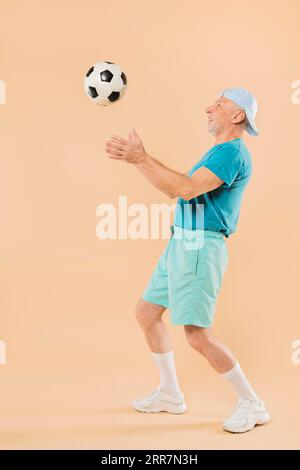 Moderner Seniormann mit Fußball Stockfoto
