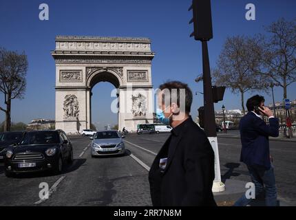 210401 -- PARIS, 1. April 2021 -- Menschen gehen in der Nähe des Triumphbogens in Paris, Frankreich, 31. März 2021. Um die Ausbreitung des Coronavirus zu verlangsamen und den Weg für eine schrittweise Rückkehr zur Normalität bis Mitte Mai zu ebnen, werden die Schulen in Frankreich für drei Wochen geschlossen und die in vielen Regionen bereits geltende Beschränkung der Personenbewegungen auf das gesamte Hoheitsgebiet ausgedehnt. Präsident Emmanuel Macron gab am Mittwochabend bekannt. FRANCE-PARIS-COVID-19-NATIONWIDE PARTIAL LOCKDOWN GAOXJING PUBLICATIONXNOTXINXCHN Stockfoto