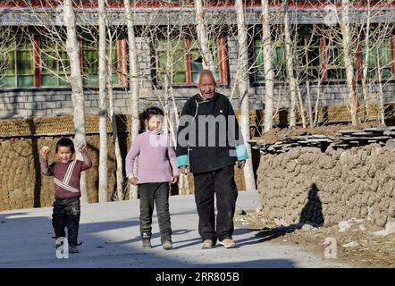 210410 -- LHASA, 10. April 2021 -- Dawa Gokye geht mit seinen Enkelkindern im Gyadu Village der Jangra Township im Gyangze County der Stadt Xigaze, südwestchinesische Autonome Region Tibet, 22. März 2021. Dawa Gokye, 76, einst Leibeigene in einem lokalen Herrenhaus Tibets, hatte bis zur demokratischen Reform 1959 in Hoffnungslosigkeit und Verzweiflung gelebt. In den Augen der Sklavenhalter sind Sklaven nichts anderes als sprechende Werkzeuge, die ihnen ausgeliefert sind. Dawa erinnerte sich, dass sein Kopf vom Verwalter des Herrenhauses schwer verletzt wurde, da der damals 8-Jährige das Wasser nicht heiß kochte, während er den Tee braute. Zusammen mit Zehntausenden anderen Stockfoto