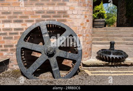 Riesiges, rostendes, verlassenes Schwungrad aus einer viktorianischen Ära mit Hubmotor und alten Eisenwerken Stockfoto