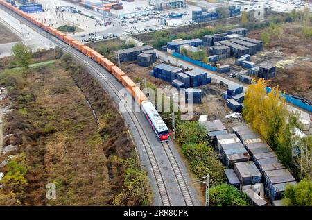 210411 -- CHENGDU, 11. April 2021 -- Luftbild zeigt einen China-Europa-Güterzug nach Helsinki, Finnland, der am 20. November 2020 von der Putian Station in Zhengzhou, der zentralchinesischen Provinz Henan, abfährt. Xinhua Schlagzeilen: Blockchain treibt den China-Europa-Schienenverkehr an HaoxYuan PUBLICATIONxNOTxINxCHN Stockfoto