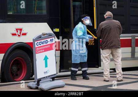 210413 -- TORONTO, 13. April 2021 -- Ein Mediziner spricht am 13. April 2021 mit einem Mann vor einem COVID-19-Testbus in Toronto, Ontario, Kanada. In der vergangenen Woche gab es einen Anstieg von 33 Prozent bei den täglichen Fallzahlen mit einem Durchschnitt von fast 8.100 neuen Fällen pro Tag, laut der Public Health Agency of Canada am Dienstag. Foto von /Xinhua CANADA-TORONTO-COVID-19-AVERAGE DAILY CASES-INCREASE ZouxZheng PUBLICATIONxNOTxINxCHN Stockfoto