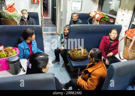 210414 -- CHANGSHA, 14. April 2021 -- Passagiere sprechen im Zug 7266 in der zentralchinesischen Provinz Hunan, 11. April 2021. Die Züge der Baureihen 7265/7266/7267 nahmen 1995 ihren Betrieb auf und erstreckten sich über 300 Kilometer vom Bahnhof Huaihua bis zum Bahnhof Lixian. Die Züge fahren in 9 Stunden und 16 Minuten an 37 Haltestellen vorbei. Die Ticketpreise liegen zwischen 1 Yuan und 23,5 Yuan (ca. 0,15 bis 3,59 US-Dollar), die in 26 Jahren nicht erhöht wurden. Die Züge fahren durch die Wuling Mountains. Dank ihnen können Dorfbewohner nicht nur Obst, Gemüse und andere lokale Produkte zum Verkauf bringen, sondern auch mich Stockfoto