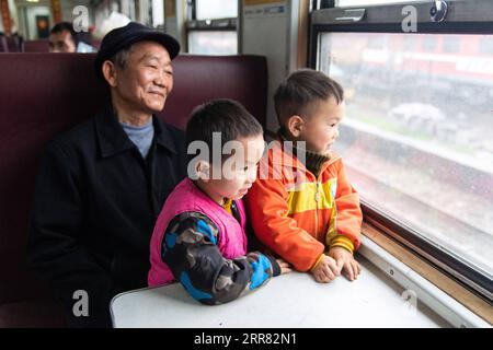 210414 -- CHANGSHA, 14. April 2021 -- Passagiere schauen aus dem Zug 7266 in der zentralchinesischen Provinz Hunan, 11. April 2021. Die Züge der Baureihen 7265/7266/7267 nahmen 1995 ihren Betrieb auf und erstreckten sich über 300 Kilometer vom Bahnhof Huaihua bis zum Bahnhof Lixian. Die Züge fahren in 9 Stunden und 16 Minuten an 37 Haltestellen vorbei. Die Ticketpreise liegen zwischen 1 Yuan und 23,5 Yuan (ca. 0,15 bis 3,59 US-Dollar), die in 26 Jahren nicht erhöht wurden. Die Züge fahren durch die Wuling Mountains. Dank ihnen können Dorfbewohner nicht nur Obst, Gemüse und andere lokale Produkte zum Verkauf bringen, sondern auch als Stockfoto