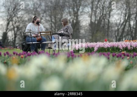 210415 -- BRÜSSEL, 15. April 2021 -- Leute unterhalten sich im Floralia Brüssel, oder der 18. Ausgabe der internationalen Blumenausstellung, im Grand Bigard Schloss in der Nähe von Brüssel, Belgien, 14. April 2021. Die Ausstellung dauert bis zum 2. Mai. Der 14 Hektar große Park zeigt mehr als eine Million Blumen mit fast 400 Tulpenarten. Hyazinthen und Narzissen sind ebenfalls gut vertreten. BELGIEN-BRÜSSEL-BLUMENAUSSTELLUNG ZhengxHuansong PUBLICATIONxNOTxINxCHN Stockfoto