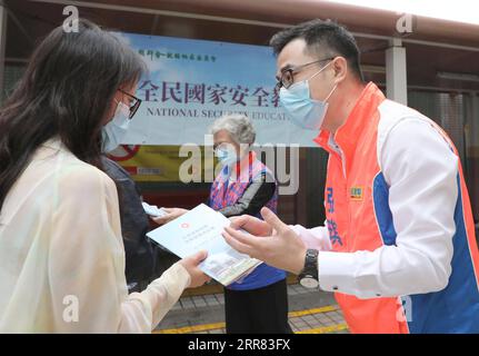 210415 -- HONGKONG, 15. April 2021 -- Ein Freiwilliger R popularisiert nationale Sicherheit in Südchinas Hong Kong, am 15. April 2021. Hongkong hat am Donnerstag seinen ersten Tag der Aufklärung über nationale Sicherheit gefeiert, nachdem das Gesetz über den Schutz der nationalen Sicherheit in der Sonderverwaltungsregion Hongkong HKSAR Mitte 2020 in Kraft getreten ist. Verschiedene Aktivitäten, darunter Vorträge, Ausstellungen, Mosaikwände und offene Tage disziplinierter Dienstleistungen, wurden durchgeführt, um das Bewusstsein der Öffentlichkeit für den Schutz der nationalen Sicherheit im globalen Finanzzentrum zu stärken. CHINA-HONGKONG-NATIONALER SICHERHEITSTAG CN W Stockfoto