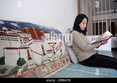 210418 -- TIANSHUI, 18. April 2021 -- Huang Jingrong liest ein Buch zur Inspiration zu Hause in der Stadt Tianshui, nordwestchinesische Provinz Gansu, 14. April 2021. Die Stadt Tianshui in der nordwestchinesischen Provinz Gansu hat eine lange Tradition in der Herstellung von Seidenteppichen. Die Technik, die mehr als 20 Verfahren umfasst, wurde 2014 aufgrund ihres künstlerischen Werts und ihrer Komplexität als nationales immaterielles Kulturerbe aufgeführt. Huang Jingrong, 49, begann mit 18 Jahren in der Xintian Silk Carpet Company ihre Reise zur Herstellung von Seidentapisserien. Seit dem ersten Tag scheute sie sich nie vor der Drogerie von Stockfoto