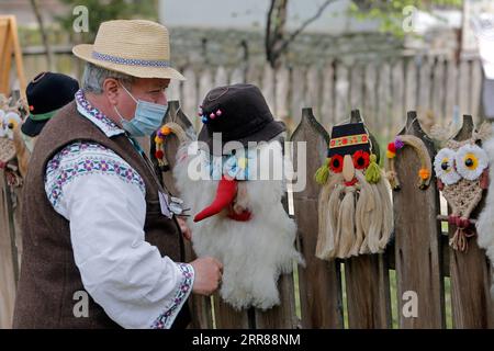 210425 -- BUKAREST, 25. April 2021 -- ein Handwerker wartet auf Kunden während einer traditionellen Frühlingsmesse für handgefertigte Handwerkskunst, die im rumänischen Dorfmuseum in Bukarest, Rumänien, am 24. April 2021 organisiert wird. Handwerker aus dem ganzen Land kamen im Dorfmuseum an, um ihre Handwerkskunst zu beweisen und ihre Waren zu verkaufen. Foto von /Xinhua ROMANIA-BUKAREST-HANDWERKSMESSE CristianxCristel PUBLICATIONxNOTxINxCHN Stockfoto