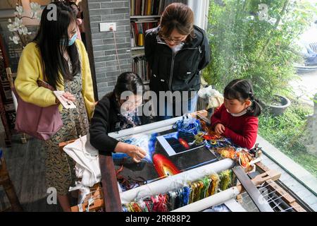 210425 -- SUZHOU, 25. April 2021 -- Chen Yinghua 3rd R demonstriert die Technik der Suzhou-Stickerei für Touristen in ihrem Atelier in Suzhou, Ostchinas Provinz Jiangsu, 14. April 2021. Chen Yinghua, eine Stickkünstlerin, hat ihr eigenes Universum mit Nadeln und Seidenfäden zur Eröffnungszeremonie des Weltraumtages von China gebracht, der hier am Samstag stattfindet. Chens Studio mit Sitz in Suzhou, einer Stadt mit altehrwürdigen Stickkunst in der ostchinesischen Provinz Jiangsu, übertrifft seine Kollegen mit einer Reihe von Kunstwerken zum Thema Kosmos. Die traumhaften Himmelskörper in ihrem Studio sind geschickt gestrickt Stockfoto