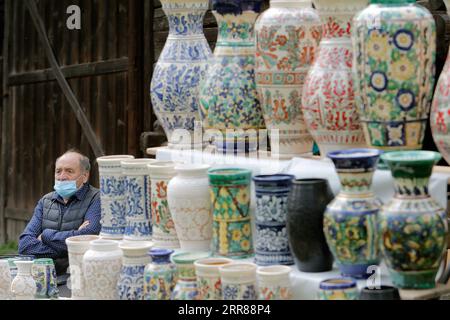 210425 -- BUKAREST, 25. April 2021 -- ein Handwerker wartet auf Kunden während einer traditionellen Frühlingsmesse für handgefertigte Handwerkskunst, die im rumänischen Dorfmuseum in Bukarest, Rumänien, am 24. April 2021 organisiert wird. Handwerker aus dem ganzen Land kamen im Dorfmuseum an, um ihre Handwerkskunst zu beweisen und ihre Waren zu verkaufen. Foto von /Xinhua ROMANIA-BUKAREST-HANDWERKSMESSE CristianxCristel PUBLICATIONxNOTxINxCHN Stockfoto