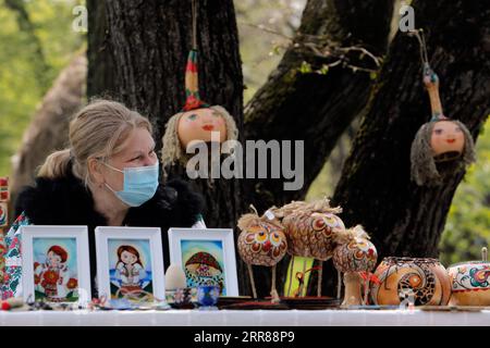 210425 -- BUKAREST, 25. April 2021 -- ein Handwerker wartet auf Kunden während einer traditionellen Frühlingsmesse für handgefertigte Handwerkskunst, die im rumänischen Dorfmuseum in Bukarest, Rumänien, am 24. April 2021 organisiert wird. Handwerker aus dem ganzen Land kamen im Dorfmuseum an, um ihre Handwerkskunst zu beweisen und ihre Waren zu verkaufen. Foto von /Xinhua ROMANIA-BUKAREST-HANDWERKSMESSE CristianxCristel PUBLICATIONxNOTxINxCHN Stockfoto