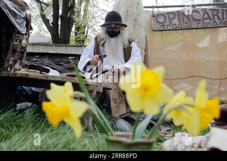 210425 -- BUKAREST, 25. April 2021 -- ein Handwerker wartet auf Kunden während einer traditionellen Frühlingsmesse für handgefertigte Handwerkskunst, die im rumänischen Dorfmuseum in Bukarest, Rumänien, am 24. April 2021 organisiert wird. Handwerker aus dem ganzen Land kamen im Dorfmuseum an, um ihre Handwerkskunst zu beweisen und ihre Waren zu verkaufen. Foto von /Xinhua ROMANIA-BUKAREST-HANDWERKSMESSE CristianxCristel PUBLICATIONxNOTxINxCHN Stockfoto