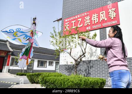 210426 -- JINAN, 26. April 2021 -- Yang Hongwei fliegt im Dorf Yangjiabu, Stadt Weifang in der ostchinesischen Provinz Shandong, 16. April 2021, einen Drachen vor Gericht. Yang Hongwei, geboren in einer Kiteherstellerfamilie in Yangjiabu, begab sich 1982 unter der Leitung ihres Großvaters auf ihre Reise der Kiteherstellung. In den folgenden fast 40 Jahren entwickelte Yang das kulturelle Erbe und gewann ihre Werke viele Auszeichnungen. Als Drachenmeisterin wurde sie auch in andere Länder eingeladen, darunter Deutschland, Australien, die Vereinigten Staaten und Neuseeland, um die Drachenkultur zu fördern und Auszubildende auszubilden. Berühmt Stockfoto