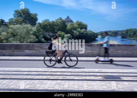 Tours, Frankreich - 3. September 2023: Schwenkende Fotografie von Touristen, die mit dem Fahrrad und Elektroroller auf der Wilson Bridge in Tours reisen Stockfoto