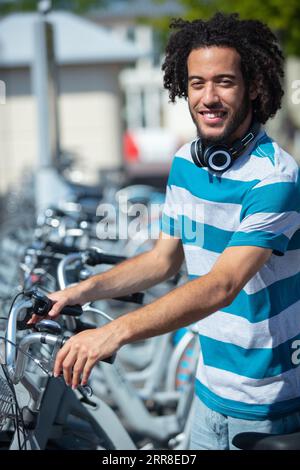 Junge attraktive Schülerin mietet Fahrrad Stockfoto