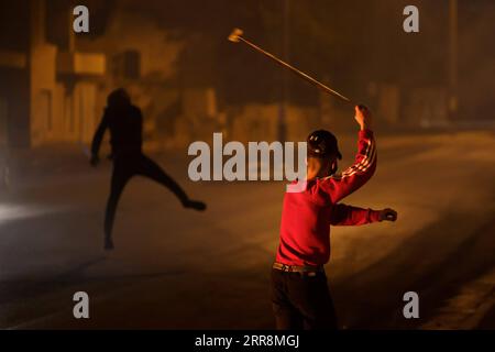 210513 -- BETHLEHEM, 13. Mai 2021 -- Ein Demonstrant schleudert einen Stein auf Mitglieder der israelischen Grenzpolizei, nachdem er am 12. Mai 2021 in Jerusalem, der Stadt Bethlehem im Westjordanland, gegen die Gewalt protestiert hatte. Die Spannungen zwischen Israelis und Palästinensern haben sich in den letzten Tagen angesichts der eskalierenden Gewalt verschärft. Foto von /Xinhua MIDEAST-BETHLEHEM-CLASHES LuayxSababa PUBLICATIONxNOTxINxCHN Stockfoto