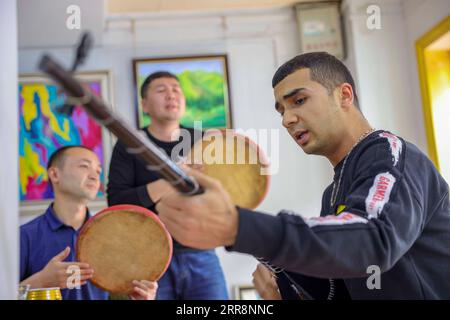 210514 -- KASHGAR, 14. Mai 2021 -- Mamattursunjian Mamatimen R spielt Musik mit Freunden in seinem Studio in der antiken Stadt Kashgar im Nordwesten Chinas Xinjiang Uygur Autonomous Region, 5. Mai 2021. Die dominierende Farbe der Wohnungen in der antiken Stadt Kashgar in Xinjiang ist tiefgelb. Aber in den Werken des 26-jährigen lokalen Malers Mamattursunjian Mamatimen, mehr Farben wie Orange, weiß, lila, blau... Werden verwendet, um die Stadt zu malen. Das ist sein Lebensgefühl, und auch ein Gefühl, das von den Jugendlichen in Kashgar geteilt wird, sagte Mamattursunjian. Es braucht Mut, die Tradition zu durchbrechen. Mamattur Stockfoto