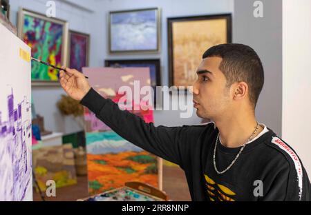 210514 -- KASHGAR, 14. Mai 2021 -- Mamattursunjian Mamatimen malt in seinem Atelier in der antiken Stadt Kashgar im Nordwesten Chinas Xinjiang Uygur Autonomous Region, 5. Mai 2021. Die dominierende Farbe der Wohnungen in der antiken Stadt Kashgar in Xinjiang ist tiefgelb. Aber in den Werken des 26-jährigen lokalen Malers Mamattursunjian Mamatimen, mehr Farben wie Orange, weiß, lila, blau... Werden verwendet, um die Stadt zu malen. Das ist sein Lebensgefühl, und auch ein Gefühl, das von den Jugendlichen in Kashgar geteilt wird, sagte Mamattursunjian. Es braucht Mut, die Tradition zu durchbrechen. Mamattursunjian sagte, als ich Stockfoto