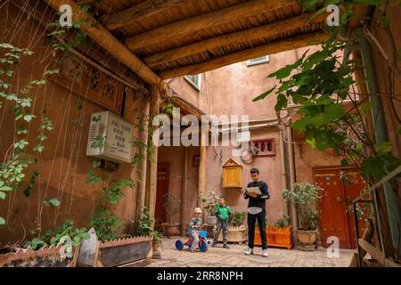 210514 -- KASHGAR, 14. Mai 2021 -- Mamattursunjian Mamatimen R malt in einer Gasse in der antiken Stadt Kashgar im Nordwesten Chinas Xinjiang Uygur Autonomous Region, 6. Mai 2021. Die dominierende Farbe der Wohnungen in der antiken Stadt Kashgar in Xinjiang ist tiefgelb. Aber in den Werken des 26-jährigen lokalen Malers Mamattursunjian Mamatimen, mehr Farben wie Orange, weiß, lila, blau... Werden verwendet, um die Stadt zu malen. Das ist sein Lebensgefühl, und auch ein Gefühl, das von den Jugendlichen in Kashgar geteilt wird, sagte Mamattursunjian. Es braucht Mut, die Tradition zu durchbrechen. Mamattursunjian sagte, als ich Stockfoto