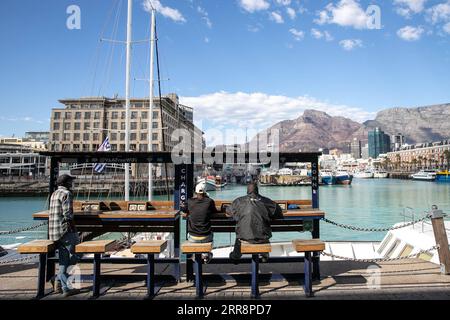 210515 -- KAPSTADT, 15. Mai 2021 -- Menschen sitzen am 14. Mai 2021 in einer Batterieladestation in der weltberühmten Touristenattraktion Victoria und Alfred Waterfront in Kapstadt, Südafrika. Kapstadt kündigte letzte Woche ein 3,9-Milliarden-Rand-Expansionsprojekt von Victoria und Alfred Waterfront in Höhe von 280 Millionen US-Dollar an. SÜDAFRIKA-KAPSTADT-UFERPROMENADE-ALLTAG LYUXTIANRAN PUBLICATIONXNOTXINXCHN Stockfoto