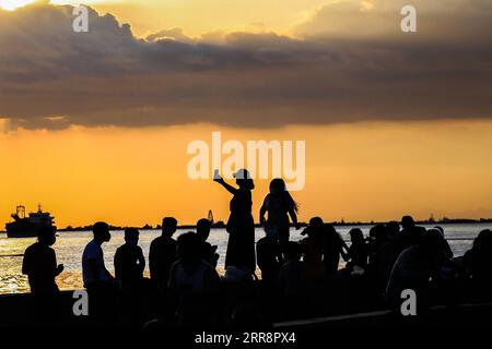 210515 -- MANILA, 15. Mai 2021 -- Menschen genießen den Sonnenuntergang in Manila Bay in Manila, Philippinen am 15. Mai 2021. PHILIPPINEN-MANILA-SUNSET RouellexUmali PUBLICATIONxNOTxINxCHN Stockfoto