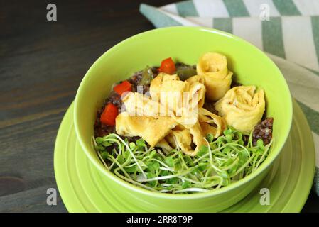 Nahaufnahme von Riceberry-Reisbrei mit gerolltem Omelette und Daikon Kaiware Microgreens Stockfoto