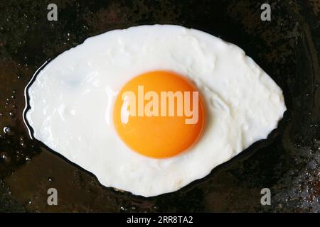 Draufsicht auf ein sonniges Ei, das in einer Pfanne gebraten wird Stockfoto