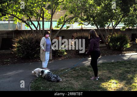 210518 -- SAN MATEO, 18. Mai 2021 -- Menschen gehen ihre Hunde in einem Park in San Mateo, Kalifornien, USA, 17. Mai 2021. Kalifornische Gesundheitsbeamte sagten Montag, der bevölkerungsreichste Staat der Vereinigten Staaten würde die CDC-Richtlinien nicht umsetzen, die es vollständig geimpften Menschen erlauben, in den meisten Situationen vor dem 15. Juni ohne Maske zu gehen. Letzte Woche sagte das US-Zentrum für Krankheitskontrolle und Prävention CDC, dass es für vollständig geimpfte Menschen sicher ist, Gesichtsbedeckungen und soziale Distanzierung in den meisten Situationen zu überspringen, und viele staaten haben ihre Maskenanforderungen angehoben. Allerdings Kalifornien Stockfoto