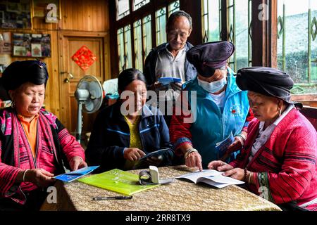 210518 -- NANNING, 18. Mai 2021 -- Pan Jiping 2nd, R stellt Wissen über Pandemieprävention im Dorf Xiaozhai in der Township Longji, County Longsheng, südchinesische autonome Region Guangxi Zhuang, 18. Mai 2021 vor. In Xiaozhai, einem Dorf am Fuße des Fupingbao-Berges auf über 1.900 Metern über dem Meeresspiegel, ist Pan Jiping seit über 30 Jahren Landarzt hier. Pan, 57, ist einer der Hongyao, ein Zweig der Yao-ethnischen Gruppe. Im Jahr 1988 ging Pan zur Gesundheitsschule des Bezirks, um Medizin zu studieren, um die Schwierigkeiten der Dorfbewohner zu lösen, einen Arzt zu besuchen. Im Jahr 1990, nach der Fertigstellung von h Stockfoto