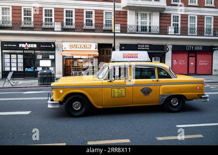 Die gelbe Kabine von DUNKIN' UK mit Fotokabine fährt die Baker Street hinunter, um die schnelle Expansion des Unternehmens in der britischen Hauptstadt anzukündigen. Bilddatum: Donnerstag, 7. September 2023. Stockfoto