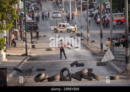 210520 -- BETHLEHEM, 20. Mai 2021 -- Ein Demonstrant hält eine palästinensische Flagge während eines Protestes gegen die anhaltenden israelischen Luftangriffe auf den Gazastreifen im Westjordanland von Bethlehem am 20. Mai 2021. Seit Beginn der israelischen Militäraktion am 10. Mai schlug Israel Gaza mit Luftangriffen und Artillerie nieder, die Wohngebäude, Straßen und andere Infrastrukturen zerstörten. Mindestens 227 Palästinenser, darunter 64 Kinder und 38 Frauen, wurden laut palästinensischen Gesundheitsbeamten im Gazastreifen getötet. In Israel wurden 12 Menschen getötet, darunter ein fünfjähriger Junge an Stockfoto