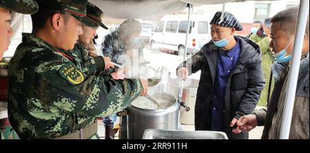 210522 -- PEKING, 22. Mai 2021 -- Foto mit dem Handy, bewaffnete Polizisten, die auf einem Platz im Maduo County der Golog Tibetan Autonomous Prefecture, nordwestchinesische Provinz Qinghai, heißes Essen verteilen, 22. Mai 2021. Nach Erdbeben wurden bewaffnete Polizisten in die Provinzen Yunnan und Qinghai entsandt, um Rettungsarbeiten durchzuführen. Vier Erdbeben mit einer Stärke von mehr als 5,0 Magnitude schlugen das autonome Yangbi Yi County in der autonomen Präfektur Dali Bai Yunnan von 21 bis 23 Uhr Freitag, Beijing Time, ein. Das Zittern war in allen 12 Grafschaften und Städten der Präfektur zu spüren, wobei Yangbi der schlechteste Hi war Stockfoto