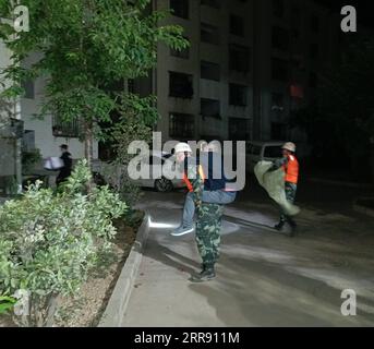 210522 -- PEKING, 22. Mai 2021 -- Foto mit einem Mobiltelefon, das bewaffnete Polizeimitglieder zeigt, die Überlebenden helfen, an sichere Orte im Yangbi Yi Autonomous County, Provinz Yunnan im Südwesten Chinas, zu ziehen, 22. Mai 2021. Nach Erdbeben wurden bewaffnete Polizisten in die Provinzen Yunnan und Qinghai entsandt, um Rettungsarbeiten durchzuführen. Vier Erdbeben mit einer Stärke von mehr als 5,0 Magnitude schlugen das autonome Yangbi Yi County in der autonomen Präfektur Dali Bai Yunnan von 21 bis 23 Uhr Freitag, Beijing Time, ein. Das Zittern war in allen 12 Grafschaften und Städten der Präfektur zu spüren, wobei Yangbi am schlimmsten getroffen wurde. Foto von /Xinhua C Stockfoto