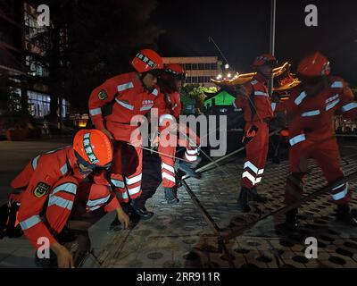 210522 -- PEKING, 22. Mai 2021 -- Foto mit dem Handy, das bewaffnete Polizeimitglieder zeigt, die nachts Zelte im Yangbi Yi Autonomous County, Provinz Yunnan im Südwesten Chinas, errichten, 22. Mai 2021. Nach Erdbeben wurden bewaffnete Polizisten in die Provinzen Yunnan und Qinghai entsandt, um Rettungsarbeiten durchzuführen. Vier Erdbeben mit einer Stärke von mehr als 5,0 Magnitude schlugen das autonome Yangbi Yi County in der autonomen Präfektur Dali Bai Yunnan von 21 bis 23 Uhr Freitag, Beijing Time, ein. Das Zittern war in allen 12 Grafschaften und Städten der Präfektur zu spüren, wobei Yangbi am schlimmsten getroffen wurde. Foto: /Xinhua CHINA-EARTHQU Stockfoto
