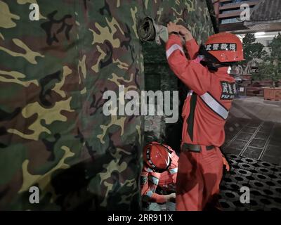 210522 -- PEKING, 22. Mai 2021 -- Foto mit dem Handy, das bewaffnete Polizeimitglieder zeigt, die nachts Zelte im Yangbi Yi Autonomous County, Provinz Yunnan im Südwesten Chinas, errichten, 22. Mai 2021. Nach Erdbeben wurden bewaffnete Polizisten in die Provinzen Yunnan und Qinghai entsandt, um Rettungsarbeiten durchzuführen. Vier Erdbeben mit einer Stärke von mehr als 5,0 Magnitude schlugen das autonome Yangbi Yi County in der autonomen Präfektur Dali Bai Yunnan von 21 bis 23 Uhr Freitag, Beijing Time, ein. Das Zittern war in allen 12 Grafschaften und Städten der Präfektur zu spüren, wobei Yangbi am schlimmsten getroffen wurde. Foto: /Xinhua CHINA-EARTHQU Stockfoto