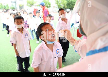 210522 -- LU AN, 22. Mai 2021 -- Ein medizinischer Arbeiter sammelt eine Abstrichprobe eines Schülers für Nukleinsäuretests an einer Grundschule in Lu an, ostchinesische Provinz Anhui, 22. Mai 2021. Von 14 Uhr Samstag bis Montag, Lu an wird eine dritte Runde von Nukleinsäure-Tests für Bewohner in den Hauptbezirken und Schlüsselbereichen, sagte die kommunale gesundheitskommission. Lu an begann am 17. Mai seine zweite Runde der COVID-19-Tests. Bis zum 19. Mai waren insgesamt 1.050.298 Proben getestet worden, die alle negativ waren. CHINA-ANHUI-LU AN-COVID-19-TEST CN ZHANGXDUAN PUBLICATIONXNOTXINXCHN Stockfoto