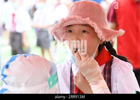 210522 -- LU AN, 22. Mai 2021 -- Ein medizinischer Arbeiter sammelt eine Abstrichprobe eines Schülers für Nukleinsäuretests an einer Grundschule in Lu an, ostchinesische Provinz Anhui, 22. Mai 2021. Von 14 Uhr Samstag bis Montag, Lu an wird eine dritte Runde von Nukleinsäure-Tests für Bewohner in den Hauptbezirken und Schlüsselbereichen, sagte die kommunale gesundheitskommission. Lu an begann am 17. Mai seine zweite Runde der COVID-19-Tests. Bis zum 19. Mai waren insgesamt 1.050.298 Proben getestet worden, die alle negativ waren. CHINA-ANHUI-LU AN-COVID-19-TEST CN ZHANGXDUAN PUBLICATIONXNOTXINXCHN Stockfoto