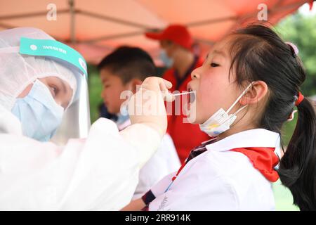 210522 -- LU AN, 22. Mai 2021 -- Ein medizinischer Arbeiter sammelt eine Abstrichprobe eines Schülers für Nukleinsäuretests an einer Grundschule in Lu an, ostchinesische Provinz Anhui, 22. Mai 2021. Von 14 Uhr Samstag bis Montag, Lu an wird eine dritte Runde von Nukleinsäure-Tests für Bewohner in den Hauptbezirken und Schlüsselbereichen, sagte die kommunale gesundheitskommission. Lu an begann am 17. Mai seine zweite Runde der COVID-19-Tests. Bis zum 19. Mai waren insgesamt 1.050.298 Proben getestet worden, die alle negativ waren. CHINA-ANHUI-LU AN-COVID-19-TEST CN ZHANGXDUAN PUBLICATIONXNOTXINXCHN Stockfoto