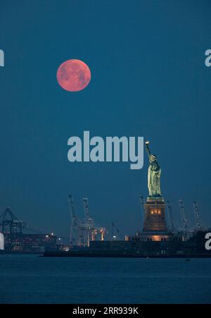 210526 -- NEW YORK, 26. Mai 2021 -- Ein Mond wird über der Freiheitsstatue in New York, den Vereinigten Staaten, gesehen, 26. Mai 2021. Am Mittwoch konnte in Teilen der Vereinigten Staaten ein Supermond beobachtet werden. U.S.-NEW YORK-MOON WangxYing PUBLICATIONxNOTxINxCHN Stockfoto