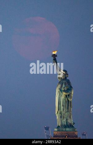 210526 -- NEW YORK, 26. Mai 2021 -- Ein Mond wird in der Wolke über der Freiheitsstatue in New York, USA, gesehen, 26. Mai 2021. Am Mittwoch konnte in Teilen der Vereinigten Staaten ein Supermond beobachtet werden. U.S.-NEW YORK-MOON WangxYing PUBLICATIONxNOTxINxCHN Stockfoto