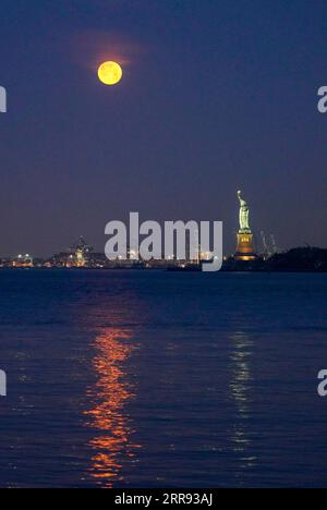 210526 -- NEW YORK, 26. Mai 2021 -- Ein Mond wird über der Freiheitsstatue in New York, den Vereinigten Staaten, gesehen, 26. Mai 2021. Am Mittwoch konnte in Teilen der Vereinigten Staaten ein Supermond beobachtet werden. U.S.-NEW YORK-MOON WangxYing PUBLICATIONxNOTxINxCHN Stockfoto