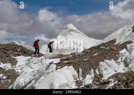 210528 -- ÜRÜMQI, 28. Mai 2021 -- Bikmirza Turdil R geht an einem Gletscher vorbei, während er an einem gezielten Training auf der Muztagh Ata in der nordwestchinesischen autonomen Region Xinjiang Uygur, 16. Mai 2021, teilnimmt. Bikmirza, ein 24-jähriger Hirte aus Kirghiz, wurde am Fuße des Muztagh Ata geboren und wuchs auf, einem Gipfel mit einer Höhe von mehr als 7.500 Metern, in den Pamirs der chinesischen Autonomen Region Xinjiang Uygur. Im Alter von 18 Jahren begann er, als Führer zu arbeiten, um Kletterern beim Tragen von Ausrüstung und Vorräten zu helfen. Der Aufstieg zum Muztagh Ata, ein Symbol für Tapferkeit, gilt sogar als die Eröffnungszeremonie für die Einheimischen Stockfoto