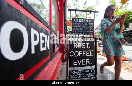 210611 -- TORONTO, 11. Juni 2021 -- Eine Frau geht am 11. Juni 2021 an einem Restaurant mit OFFENEM Schild in Toronto, Ontario, Kanada vorbei. Ontario trat am Freitag in Schritt eins seines Wiedereröffnungsplans ein, in dem Geschäfte und Restaurants vor Kunden wimmelten, als die Provinz einige ihrer COVID-19-Beschränkungen zum ersten Mal seit Monaten aufhob. Foto von /Xinhua CANADA-ONTARIO-COVID-19-REOPENING ZouxZheng PUBLICATIONxNOTxINxCHN Stockfoto