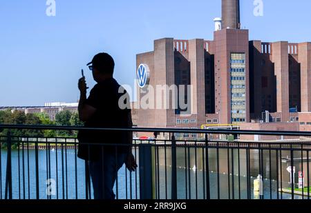 Wolfsburg, Deutschland. September 2023. Ein Mann geht am VW-Kraftwerk auf dem Gelände des Volkswagen-Hauptwerks vorbei. Quelle: Julian Stratenschulte/dpa/Alamy Live News Stockfoto