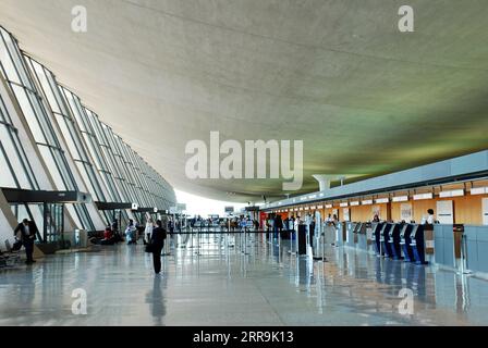 Passagiere und Reisende gehen durch das Hauptterminal des Dulles International Airport, entworfen von Eero Saarinen, in der Nähe von Washington, DC Stockfoto